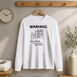 Hot Warning May Need Help With Items On High Shelves long sleeve shirt in white, front view with bold warning text