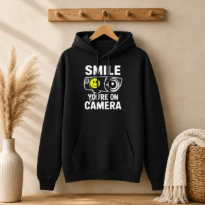 Top Smile You'Re On Camera Security Camera With Smiley Face Hoodie in black with front graphic design